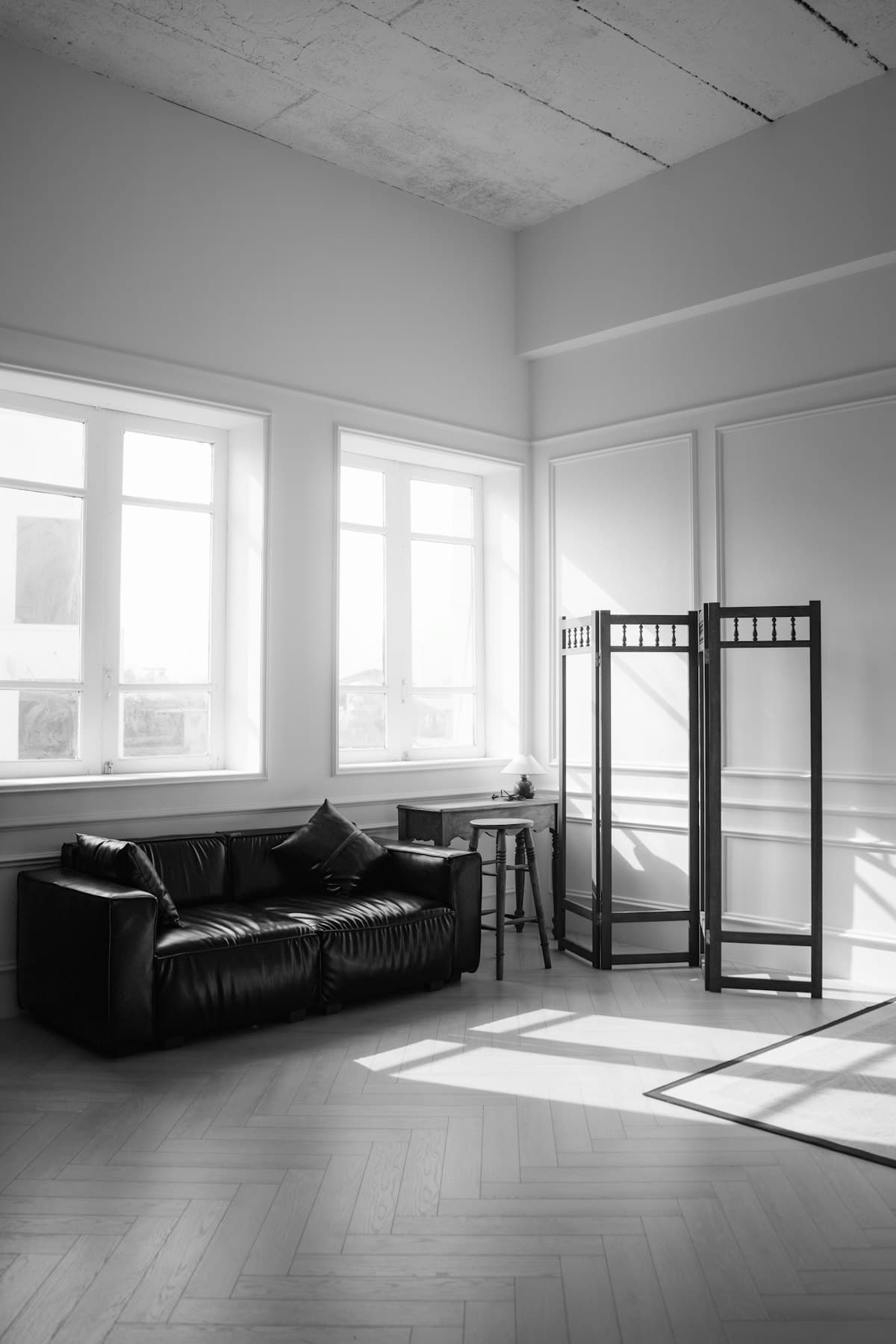 Căn phòng nhỏ đầy nắng với ghế sofa da và tấm bình phong