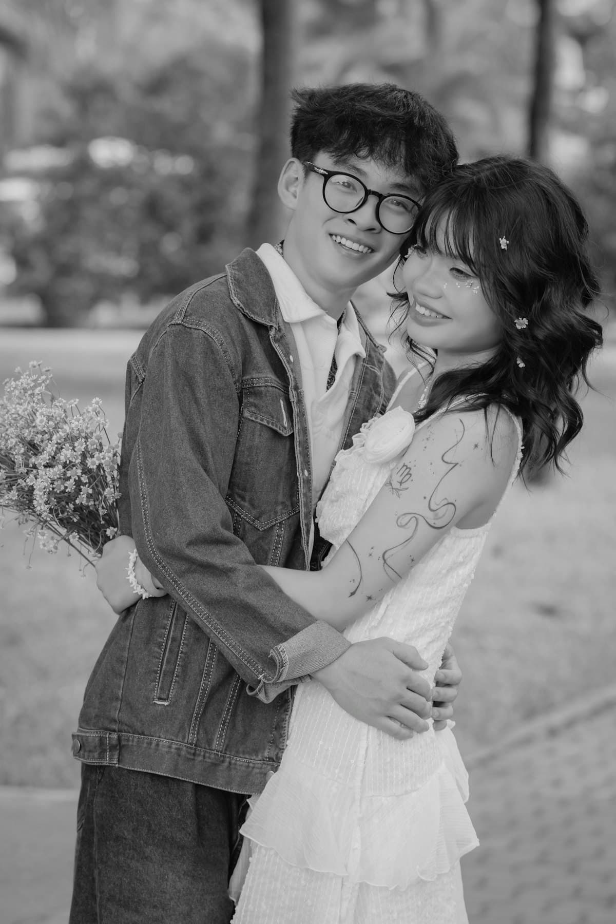 Cặp đôi ôm nhau cười trên lối đi trong công viên